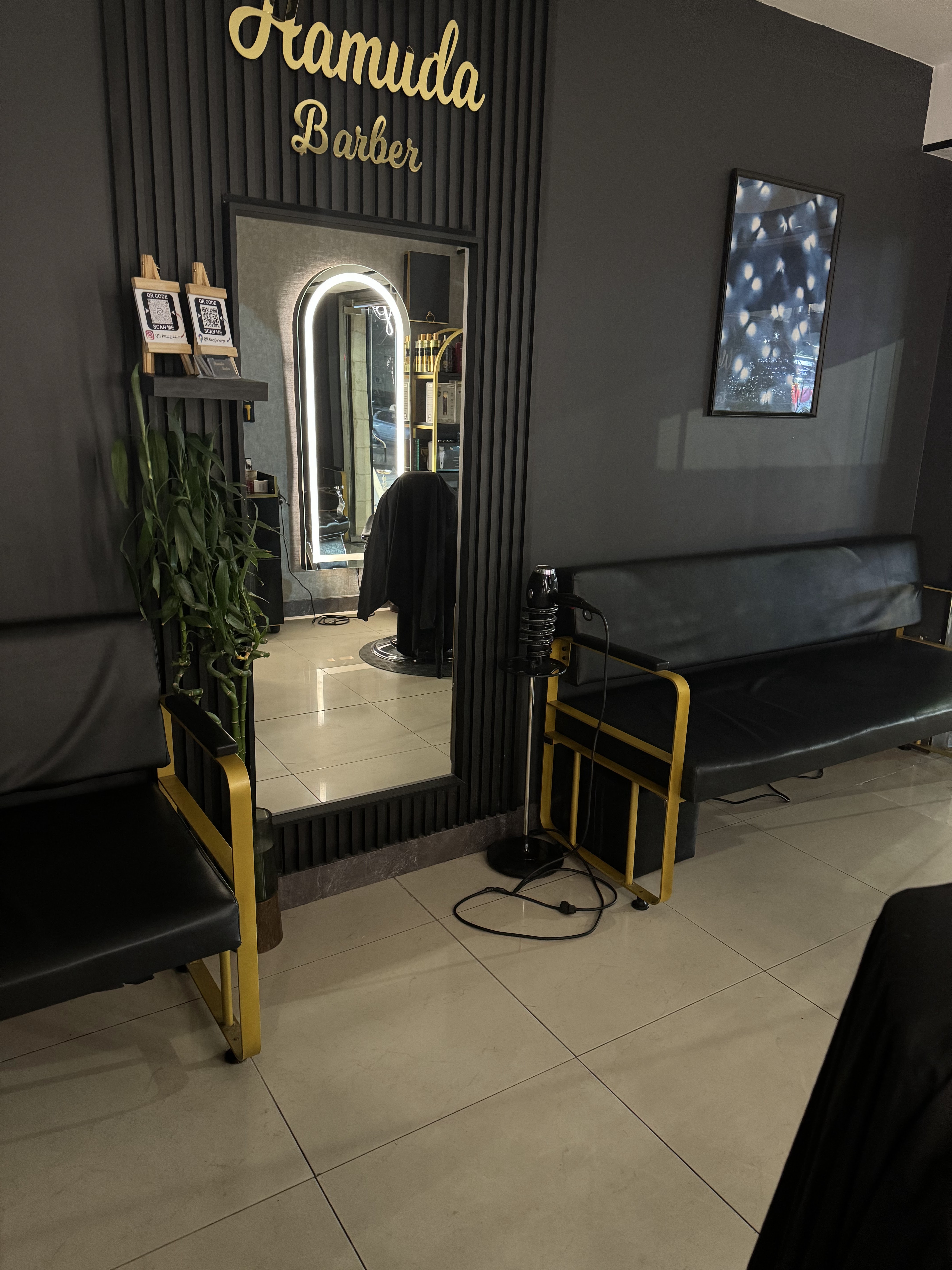Gold-lit entrance mirror beneath the Hamuda Barber sign